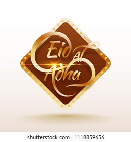 Glossy golden typographic text Eid-Al-Adha in brown square frame decorated by marquee lights. Islamic festival of sacrifice, Eid-Al-Adha celebration concept.