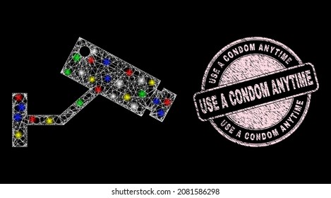Icono de cámara CCTV de red brillante con efecto brillante sobre el fondo negro con la impresión de sello texturizado de Use a Condom Anytime. El sello rosado tiene la forma redonda Usar un texto de condón en cualquier momento.