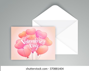 Glossy hearts shaped balloons decorated beautiful greeting card with envelope for Happy Valentine's Day celebration.