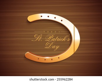 Glossy horseshoe on stylish brown background for Happy St. Patrick's Day celebration.