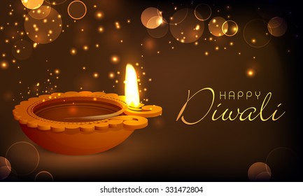 Glossy illuminated oil lit lamp on shiny brown background for Indian Festival of Lights, Happy Diwali celebration.