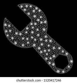 Glossy mesh wrench with glare effect. Abstract illuminated model of wrench icon. Shiny wire frame polygonal mesh wrench. Vector abstraction on a black background.