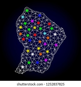 Glossy polygonal mesh map of French Guiana with glare effect. Vector carcass map of French Guiana with glowing multi colored points for Christmas illustrations. White mesh lines. Dark blue background.