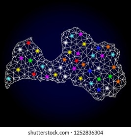 Glossy polygonal mesh map of Latvia with glow effect. Vector carcass map of Latvia with glowing multi colored points for Christmas illustrations. White mesh lines. Dark blue background.