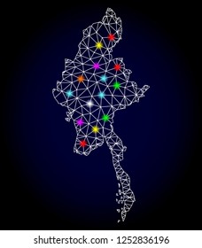 Glossy polygonal mesh map of Myanmar with glow effect. Vector carcass map of Myanmar with glowing multi colored spheres for Christmas templates. White mesh lines. Dark blue background.