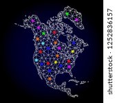 Glossy polygonal mesh map of North America with glare effect. Vector carcass map of North America with glowing multi colored dots for Christmas templates. White mesh lines. Dark blue background.