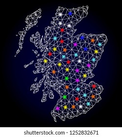Glossy polygonal mesh map of Scotland with glare effect. Vector carcass map of Scotland with glowing multicolored points for Christmas posters. White mesh lines. Dark blue background.