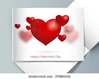 Glossy red hearts decorated elegant greeting card with envelope for Happy Valentine's Day celebration.