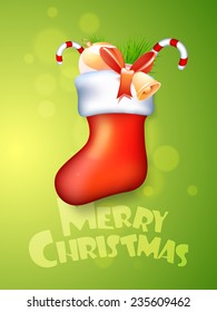 Glossy X-mas stocking with jingle bell, candy canes, decoration ball and fir tree on shiny green background for Merry Christmas celebrations.