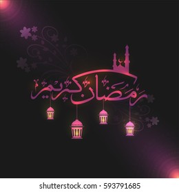 Glowing Arabic Islamic Calligraphy of Text Ramadan Kareem with hanging lamps for Holy Month of Muslim Community Festival celebration.