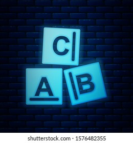Glowing neon ABC blocks icon isolated on brick wall background. Alphabet cubes with letters A,B,C.  Vector Illustration