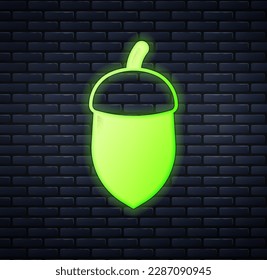 Glowing neon Acorn icon isolated on brick wall background.  Vector