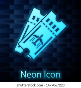 Glowing neon Airline ticket icon isolated on brick wall background. Plane ticket.  Vector Illustration