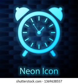Glowing neon Alarm clock icon isolated on brick wall background. Wake up, get up concept. Time sign. Vector Illustration