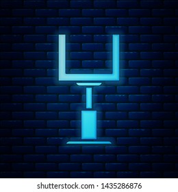 Glowing neon American football goal post icon isolated on brick wall background.  Vector Illustration