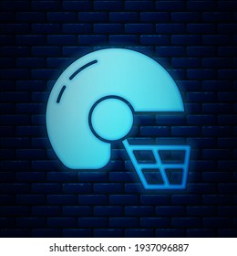 Glowing neon American football helmet icon isolated on brick wall background.  Vector