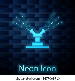 Glowing neon Automatic irrigation sprinklers icon isolated on brick wall background. Watering equipment. Garden element. Spray gun icon.  Vector Illustration