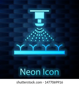 Glowing neon Automatic irrigation sprinklers icon isolated on brick wall background. Watering equipment. Garden element. Spray gun icon.  Vector Illustration