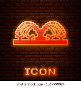 Glowing neon Automatic irrigation sprinklers icon isolated on brick wall background. Watering equipment. Garden element. Spray gun icon.  Vector Illustration