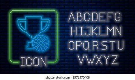 Glowing neon Award cup with basketball ball icon isolated on brick wall background. Winner trophy symbol. Championship or competition trophy. Neon light alphabet. Vector Illustration