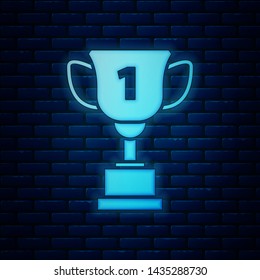 Glowing neon Award cup icon isolated on brick wall background. Winner trophy symbol. Championship or competition trophy. Sports achievement sign.  Vector Illustration