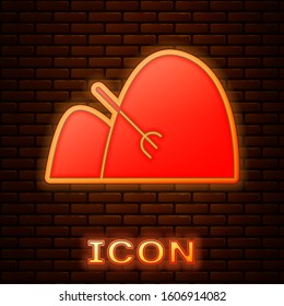 Glowing neon Bale of hay and rake icon isolated on brick wall background.  Vector Illustration