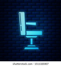 Glowing neon Barbershop chair icon isolated on brick wall background. Barber armchair sign.  Vector Illustration