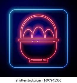 Glowing neon Basket with easter eggs icon isolated on blue background. Happy Easter.  Vector Illustration