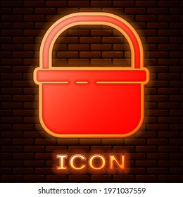 Glowing neon Basket icon isolated on brick wall background. Online buying concept. Delivery service sign. Shopping cart symbol.  Vector