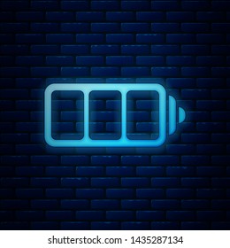 Glowing neon Battery charge level indicator icon isolated on brick wall background.  Vector Illustration