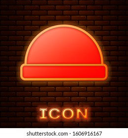 Glowing neon Beanie hat icon isolated on brick wall background.  Vector Illustration