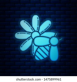 Glowing neon Bee and flower icon isolated on brick wall background. Sweet natural food. Honeybee or apis with wings symbol. Flying insect.  Vector Illustration