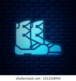 Glowing neon Boots icon isolated on brick wall background.  Vector Illustration