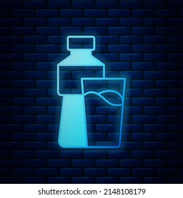 Glowing neon Bottle of water with glass icon isolated on brick wall background. Soda aqua drink sign.  Vector