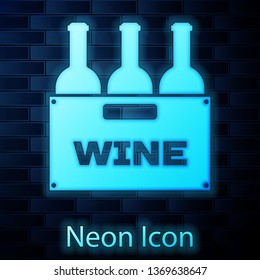 Glowing neon Bottles of wine in a wooden box icon isolated on brick wall background. Wine bottles in a wooden crate icon. Vector Illustration
