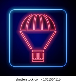 Glowing neon Box flying on parachute icon isolated on blue background. Parcel with parachute for shipping. Delivery service, air shipping.  Vector Illustration