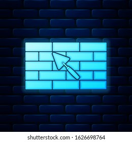 Glowing neon Brick wall with trowel icon isolated on brick wall background.  Vector Illustration