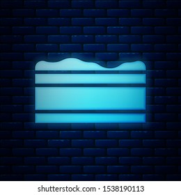 Glowing neon Brownie chocolate cake icon isolated on brick wall background.  Vector Illustration