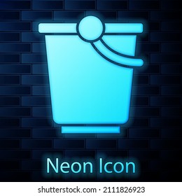 Glowing neon Bucket icon isolated on brick wall background.  Vector