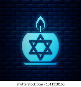 Glowing neon Burning candle in candlestick with star of david icon isolated on brick wall background. Cylindrical candle stick with burning flame.  Vector Illustration
