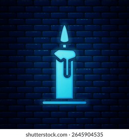 Glowing neon Burning candle in candlestick icon isolated on brick wall background. Cylindrical candle stick with burning flame.  Vector Illustration
