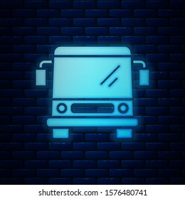 Glowing neon Bus icon isolated on brick wall background. Transportation concept. Bus tour transport sign. Tourism or public vehicle symbol.  Vector Illustration