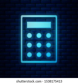 Glowing neon Calculator icon isolated on brick wall background. Accounting symbol. Business calculations mathematics education and finance.  Vector Illustration