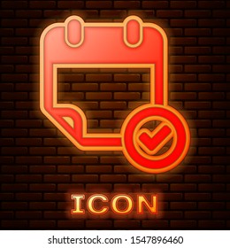 Glowing neon Calendar with check mark icon isolated on brick wall background.  Vector Illustration