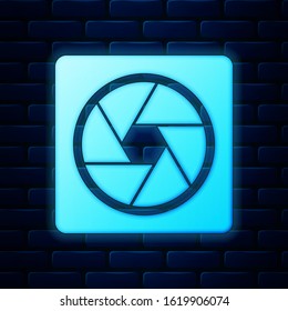 Glowing neon Camera shutter icon isolated on brick wall background.  Vector Illustration