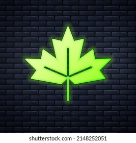 Glowing neon Canadian maple leaf icon isolated on brick wall background. Canada symbol maple leaf.  Vector