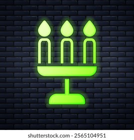 Glowing neon Candelabrum with three candlesticks icon isolated on brick wall background.  Vector