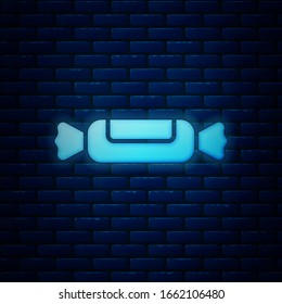 Glowing neon Candy icon isolated on brick wall background.  Vector Illustration