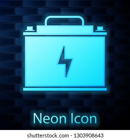 Glowing neon Car battery icon isolated on brick wall background. Accumulator battery energy power and electricity accumulator battery. Lightning bolt symbol. Vector Illustration