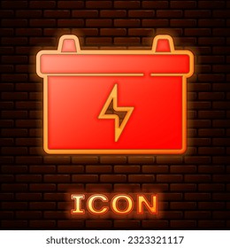 Glowing neon Car battery icon isolated on brick wall background. Accumulator battery energy power and electricity accumulator battery.  Vector